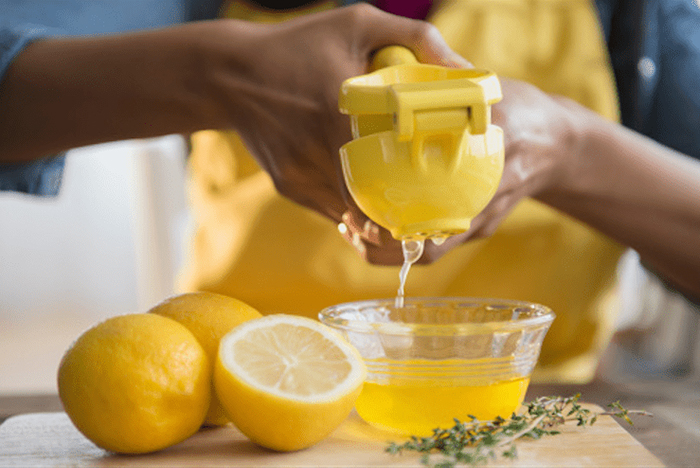 Ép nước cốt chanh tươi để thoa lên vùng da tàn nhang