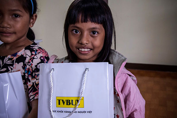 Một học sinh vui vẻ khi nhận được quà hỗ trợ đến từ TVBUY Vietnam